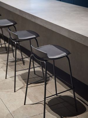 Un tabouret de bar classique, noir, léger, et des chaises de bar en cuir sophistiquées.